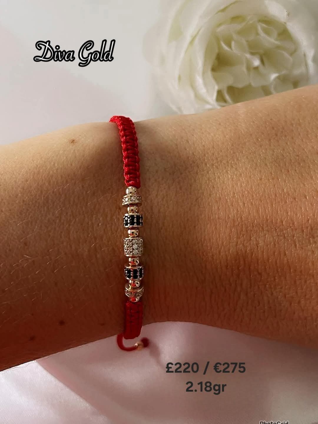 Red thread bracelet with gold details.