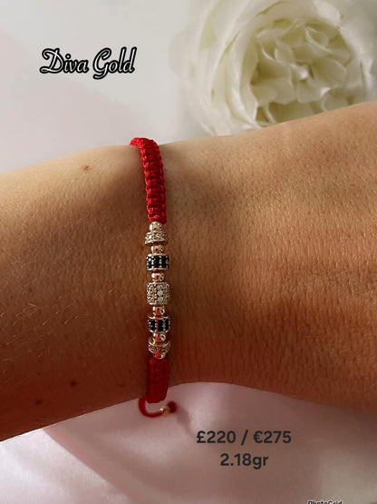 Red thread bracelet with gold details.