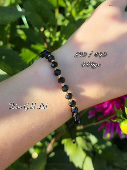 Black thread bracelet with gold details.