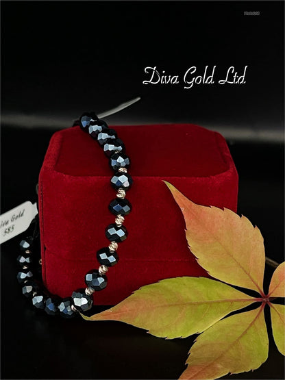 Black thread bracelet with gold details.