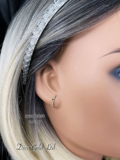 Stud gold earrings.