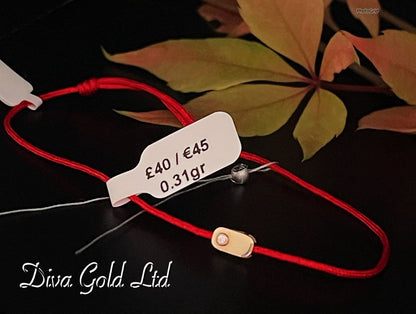 Red thread bracelet with gold details.