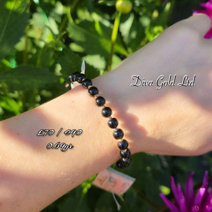 Black thread bracelet with gold details.