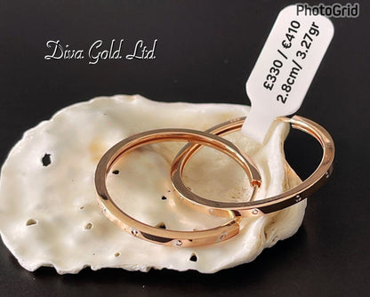 Gold 585 hoop earrings with white zircon stones.