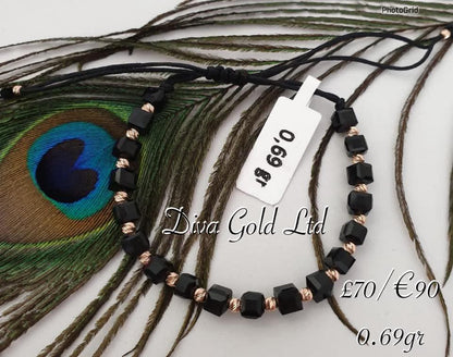 Black thread bracelet with gold details.