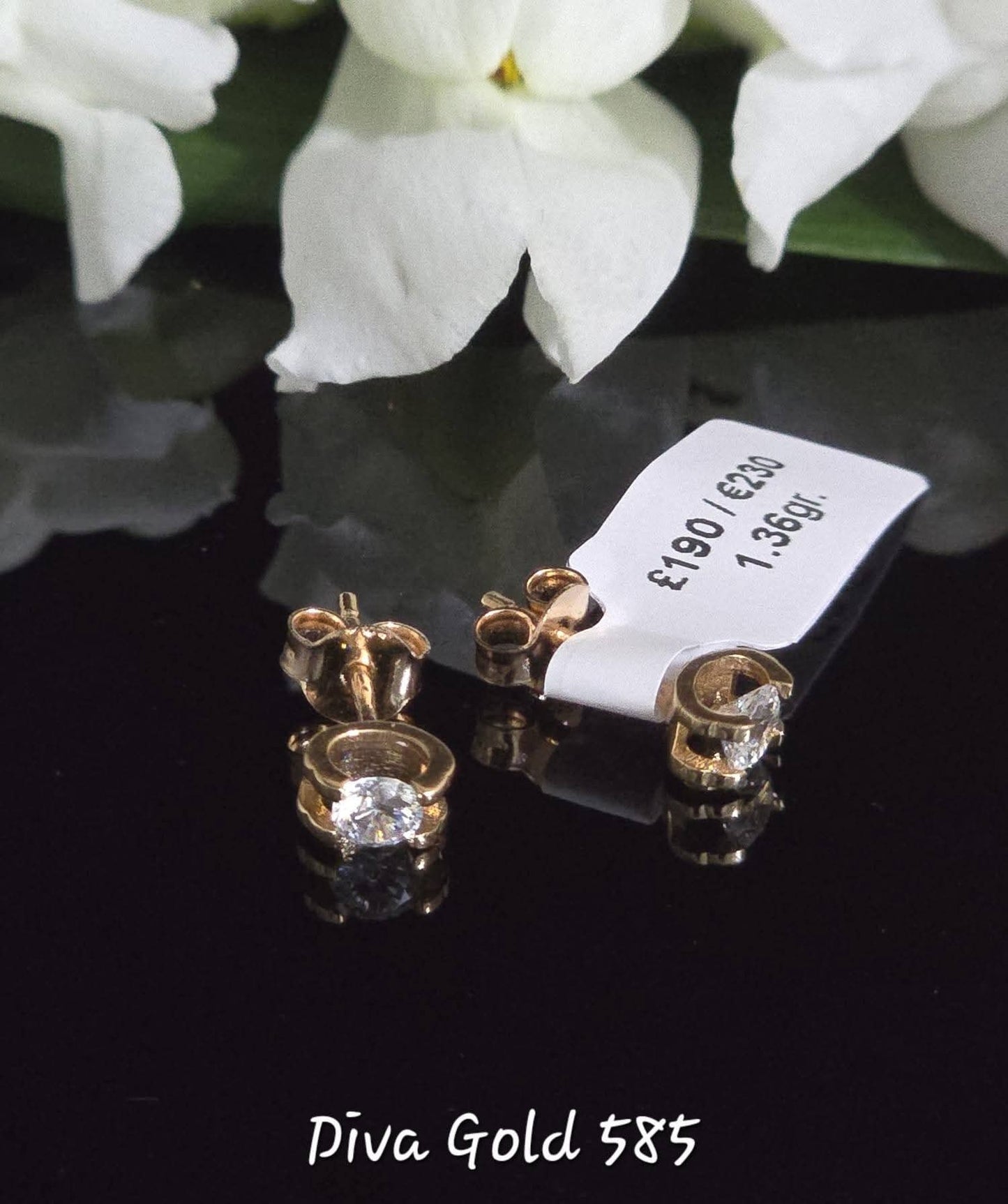 Stud gold earrings. White zircon stones